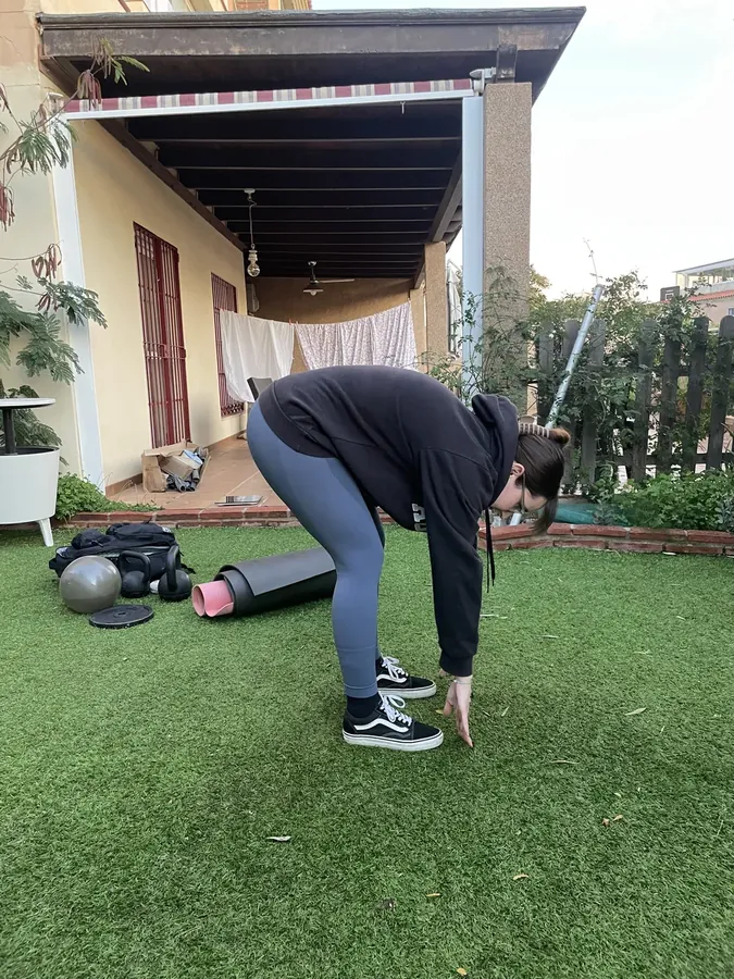 Clienta haciendo peso muerto a una pierna en la terraza de su casa