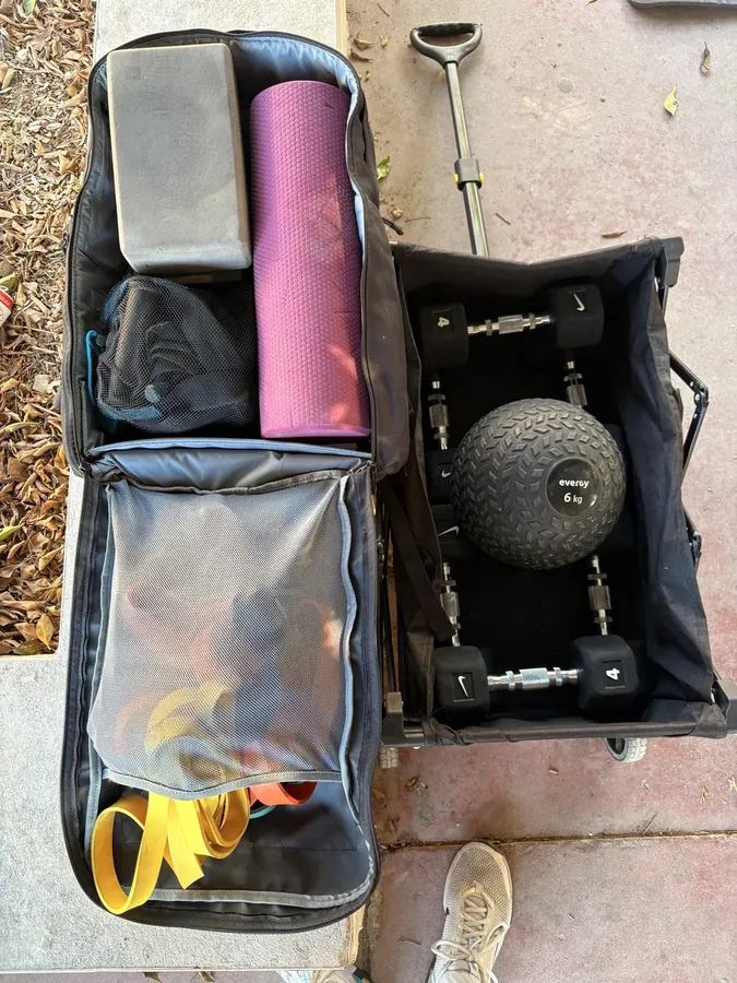 La bolsa y el carro con mancuernas, kettlebells, gomas, esterilla y balón medicinal que subo a cada domicilio en Málaga