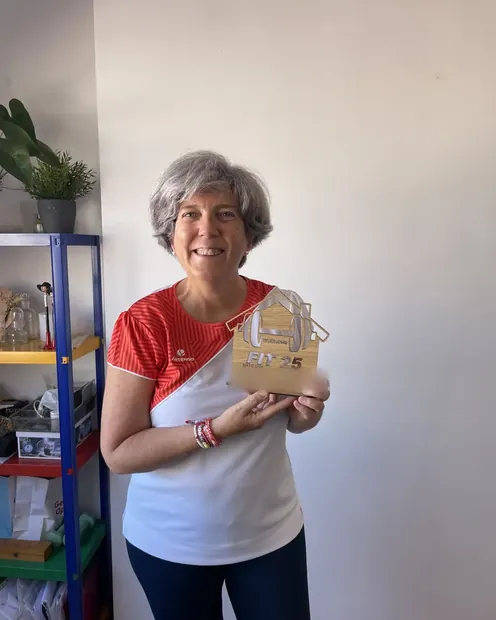 Clienta con su placa FIT 25 en el salón de su casa